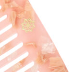 Detaillierte goldene Haarklammer auf rosafarbenem Haarstyling-Accessoire, elegant und modisch.