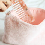 Helle pinke Haarbürste in einem kuscheligen Beutel aufbewahrt, stilvoll und praktisch für unterwegs.